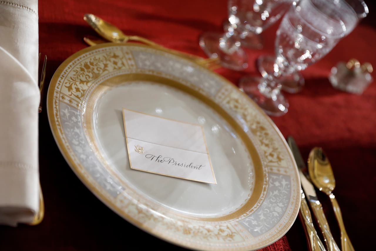 Detalle del plato con la tarjeta que señala el lugar del presidente en el almuerzo.
