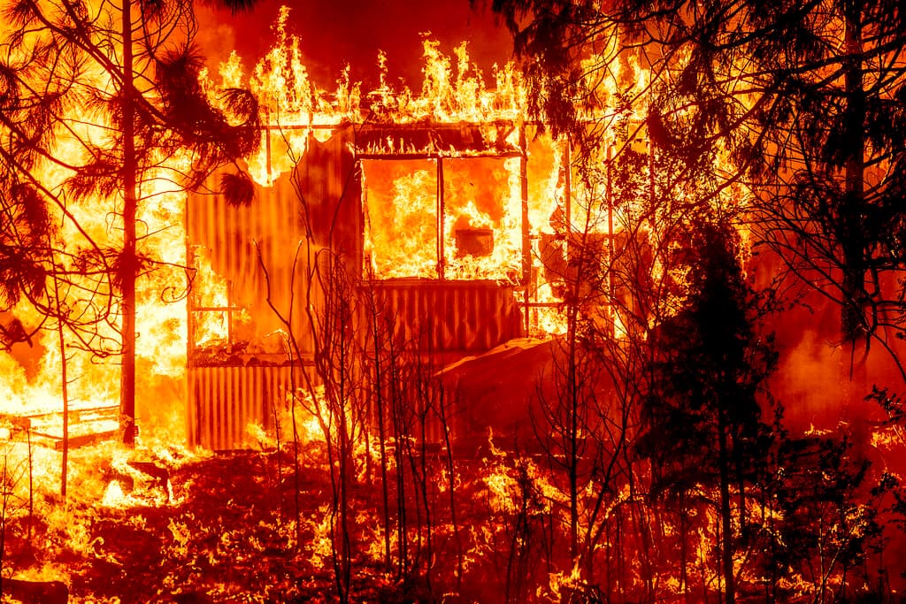 Las llamas del incendio Dixie consumen una vivienda en la Autopista 89.