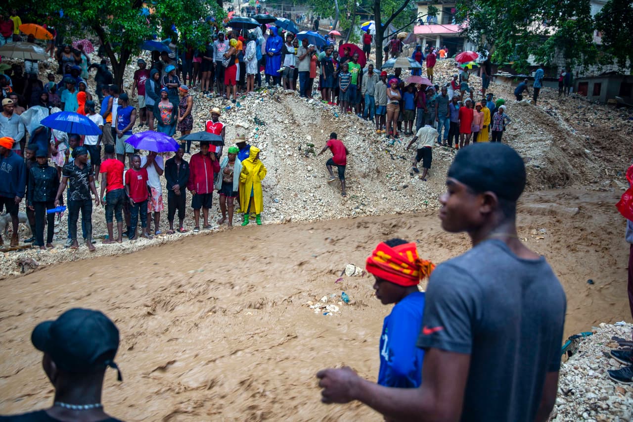 Una muchedumbre aparece en las orillas del río Tet Dlo en Haití tras el paso de la tormenta tropical Laura.