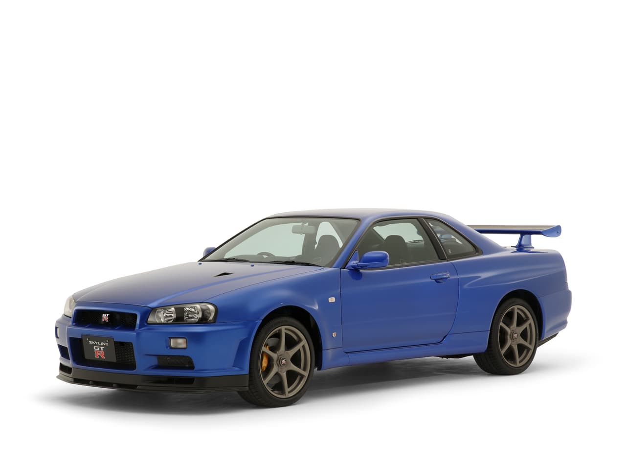 El R34 fue diseñado por Kozo Watanabe y presentado en 1999 haciendo gala de los avances tecnológicos desarrollados por Nissan durante los años que el R33 dominó las pistas de competencia. Reemplazó la transmisión manual de 5 velocidades por una de 6, control de tracción ATTESA de serie, traía una futurista pantalla LCD que mostraba información importante frente al piloto y hasta se podía ver televisión en ella. (Foto: Skyline GT-R V⋅spec II 2000 BNR34)