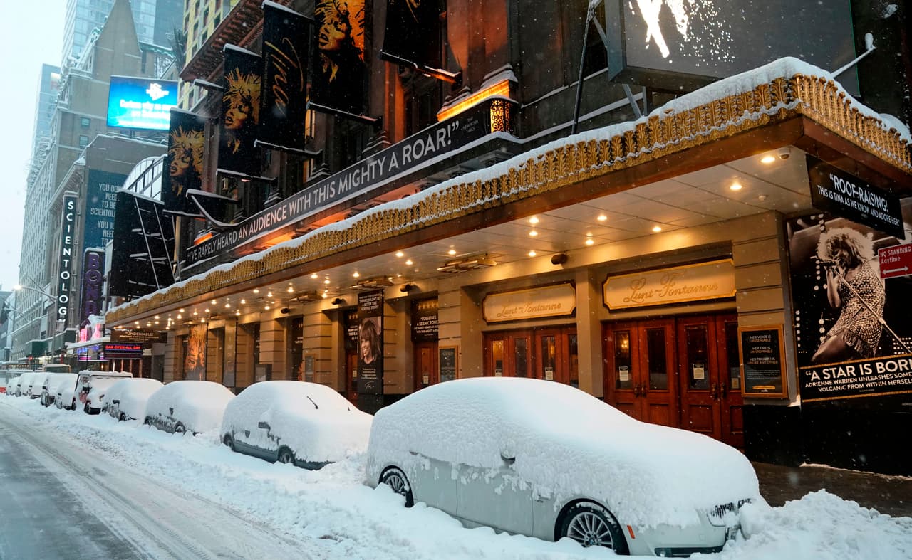 Coches cubiertos de nieve frente a los teatros de Broadway en Manhattan