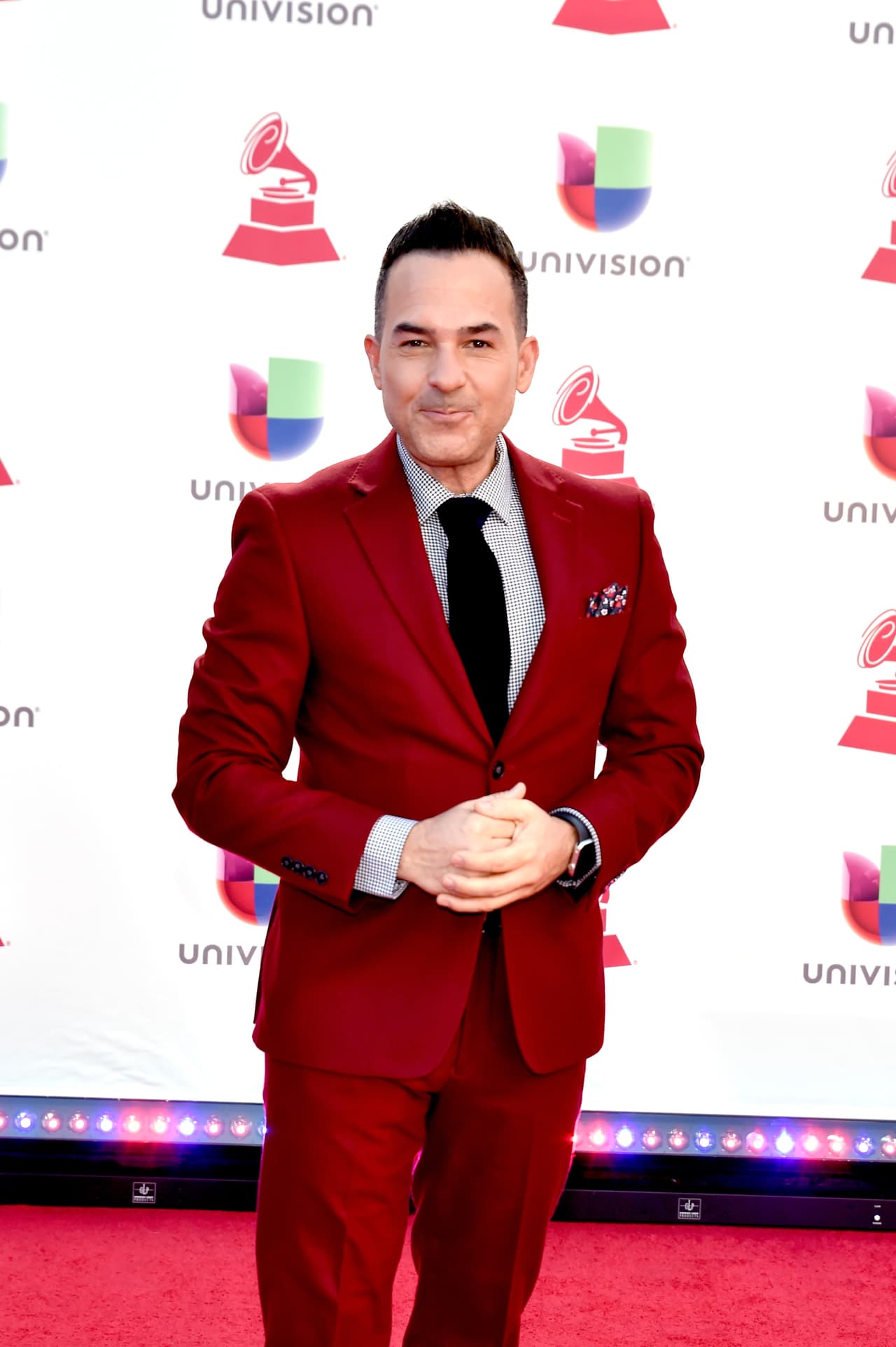 El presentador Carlos Calderón se vio más arriesgado usando un traje color rojo, pero elegante.