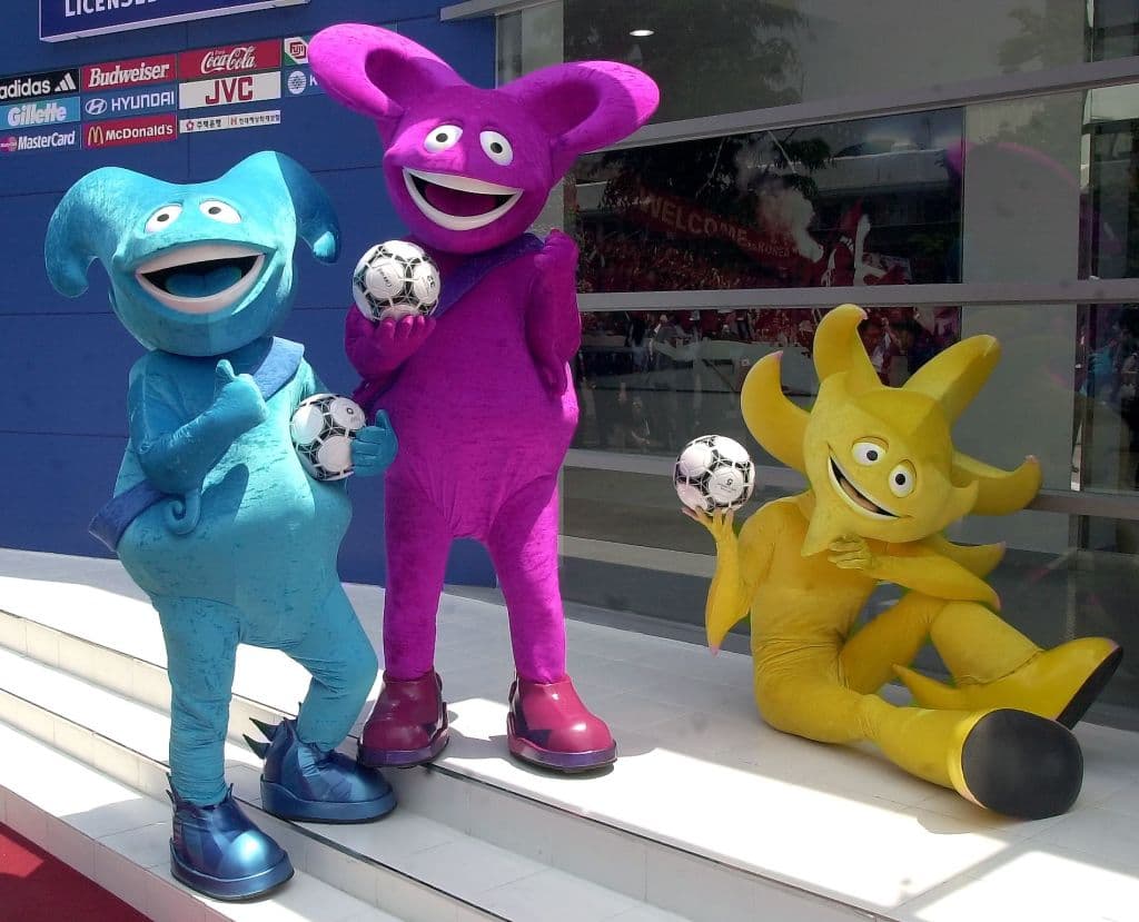 <b>Ato, Kaz y Nik - Corea/Japón 2002</b>
<br>Por primera vez no fue una sola mascota, si no tres con un diseño futurista. Una naranja, una violeta y una azul. Sus nombre fueron elegidos, también, por el público japonés.