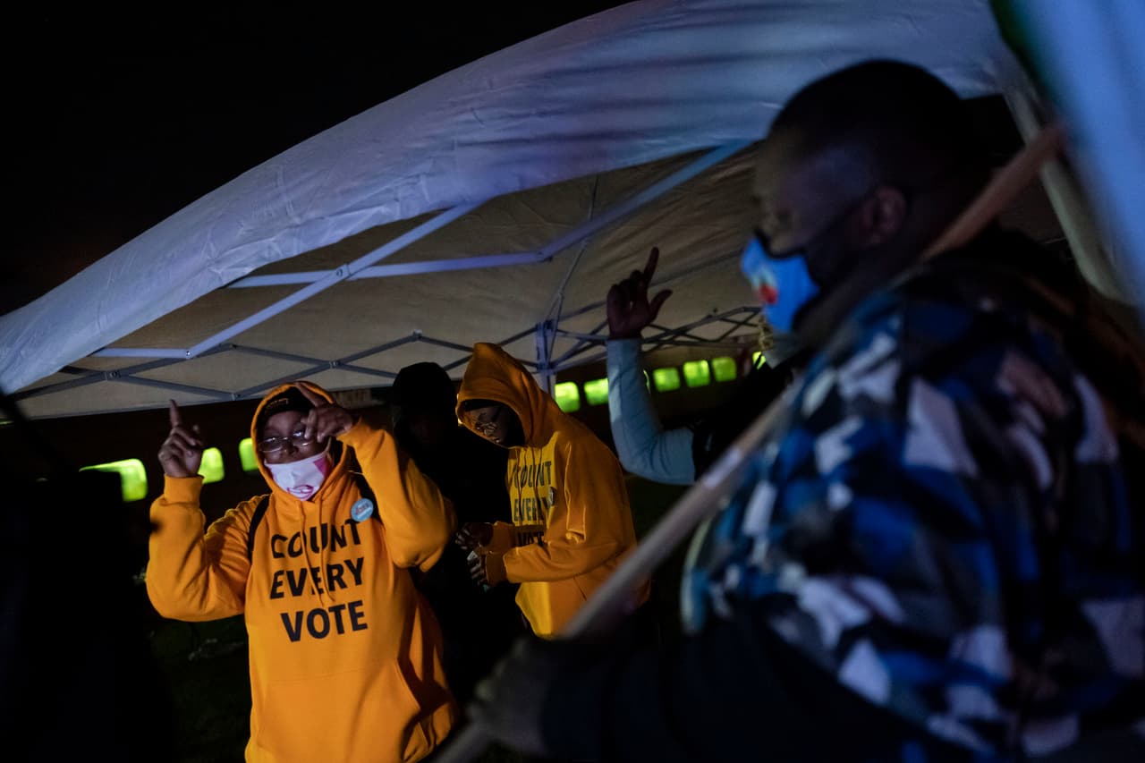 Las personas que usan jerseys con las palabras "Count Every Vote" bailan mientras monitorean los resultados de las elecciones en la televisión en una fiesta de observación el martes 3 de noviembre de 2020 en Kenosha.