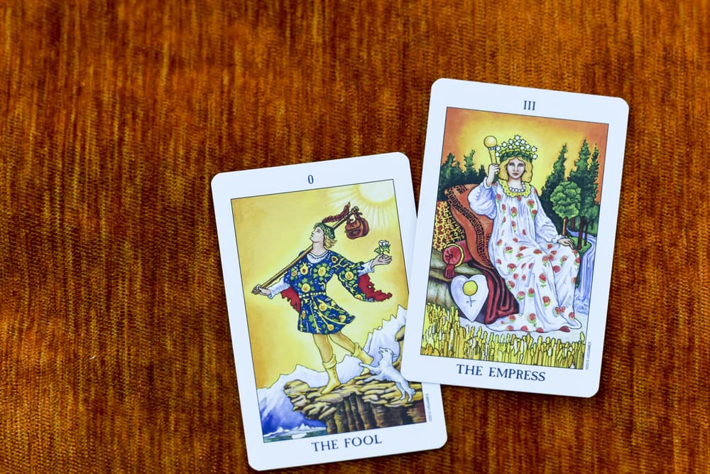 Por tanto, en la representación más popular de las barajas de tarot, la Rider Waite, este joven inicia un viaje con el sol a sus espaldas, así que se dirige al noroeste, hacia lo misterioso e incógnito. Lleva en la mano una rosa blanca, el símbolo más elemental de la pureza e inocencia. En el bolso lleva todo lo que necesita y, aunque algunos dicen que carga ahí con los cuatro elementos, en realidad ni él sabe qué lleva.