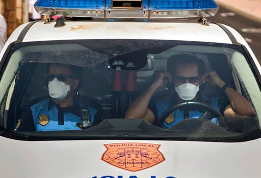 Agentes de la policía española con mascarillas mientras hacen vigilancia en un hotel en Tenerife en cuarentena por coronavirus.