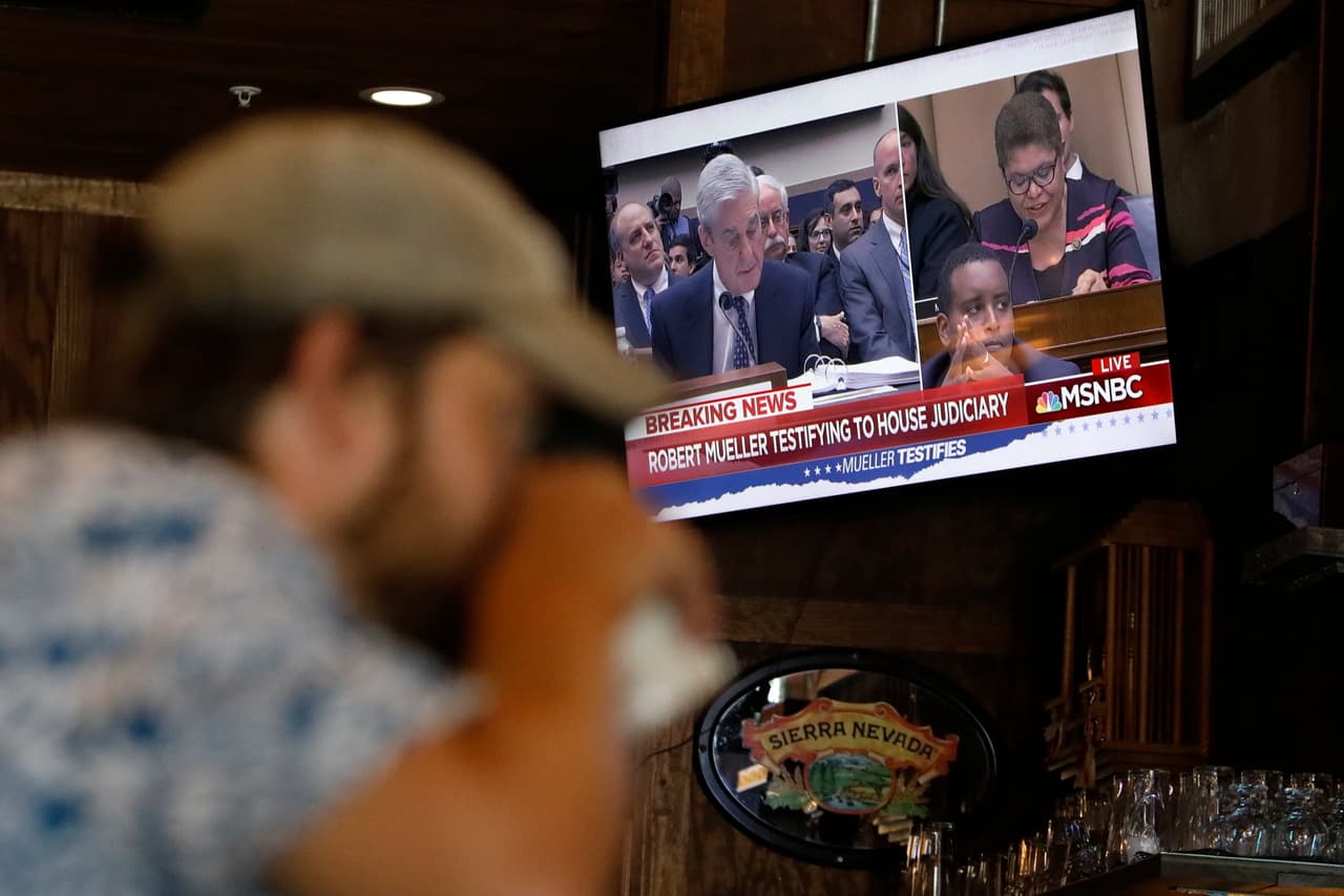 Clientes de un bar en Atlanta miran la intervención de Robert Mueller en el Congreso en uno de los televisores del local. Los representantes demócratas y republicanos cuestionaron su trabajo sobre si hubo colusión entre Rusia y la campaña del presidente Donald Trump, y si el mandatario incurrió en obstrucción a la justicia.
