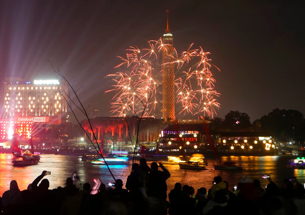 La gente disfruta de los fuegos artificiales sobre la Torre de El Cairo y el río Nilo cuando comienzan las celebraciones de Año Nuevo en El Cairo, Egipto, el domingo 1 de enero de 2023.