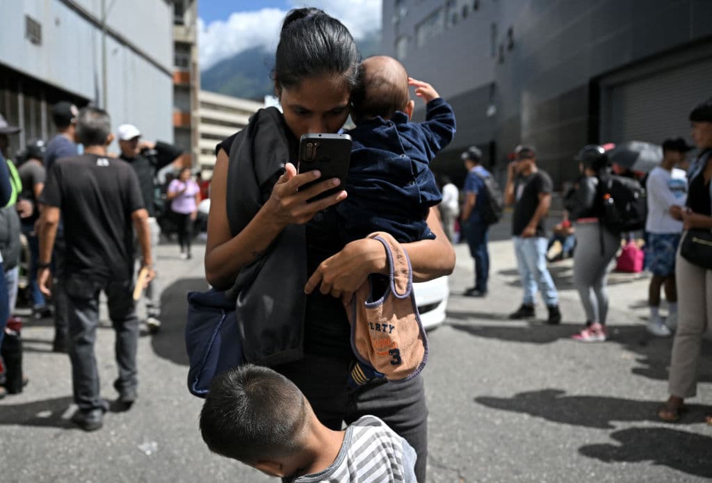 Familiares de venezolanos arrestados durante las más recientes protestas esperan saber algo sobre ellos frente a un centro de detención en Caracas.