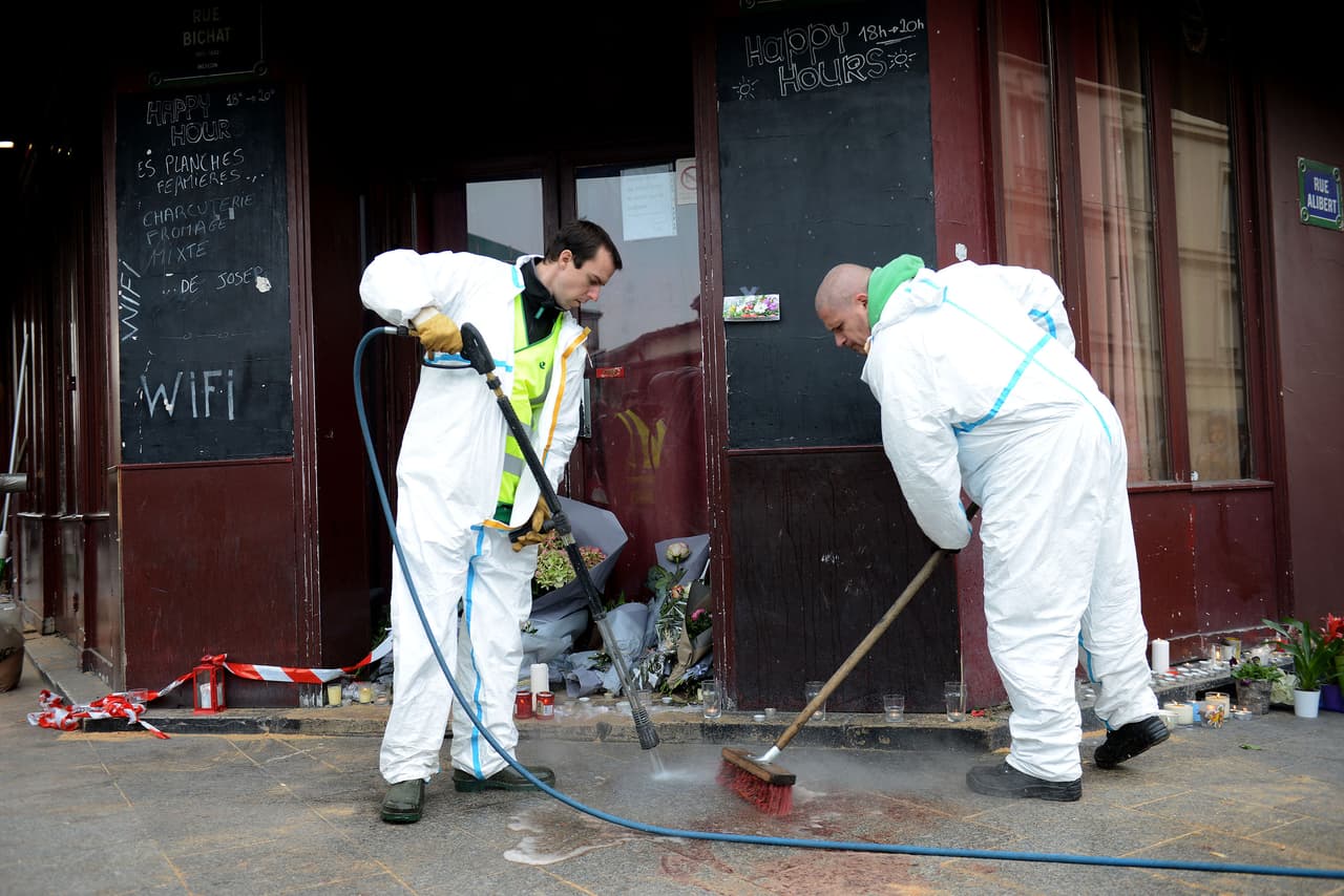 Empleados municipales limpian la sangre afuera del bar Le Carrillon, un día después de los ataques.