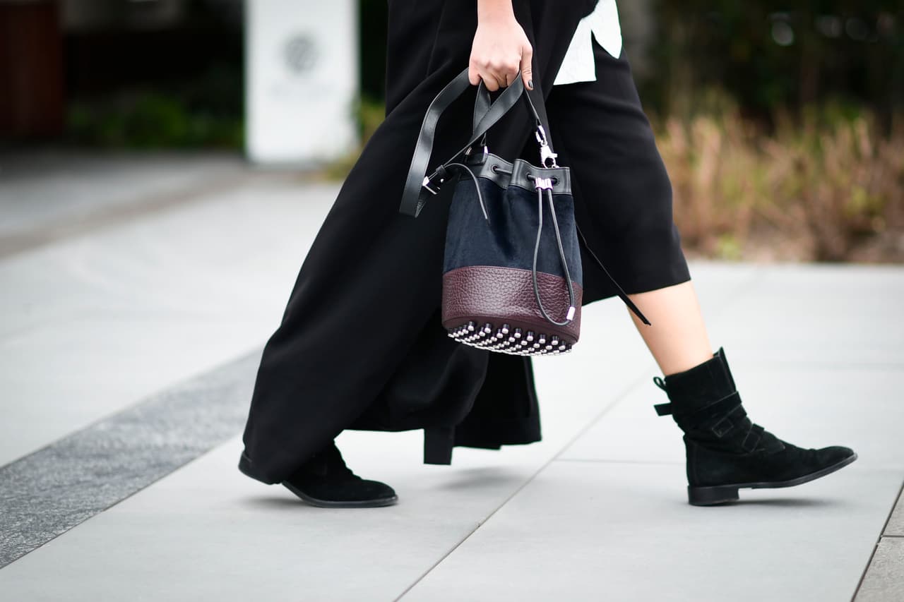 Con mezcla de colores y taches, esta cartera tipo bombonera es esencial de la temporada.