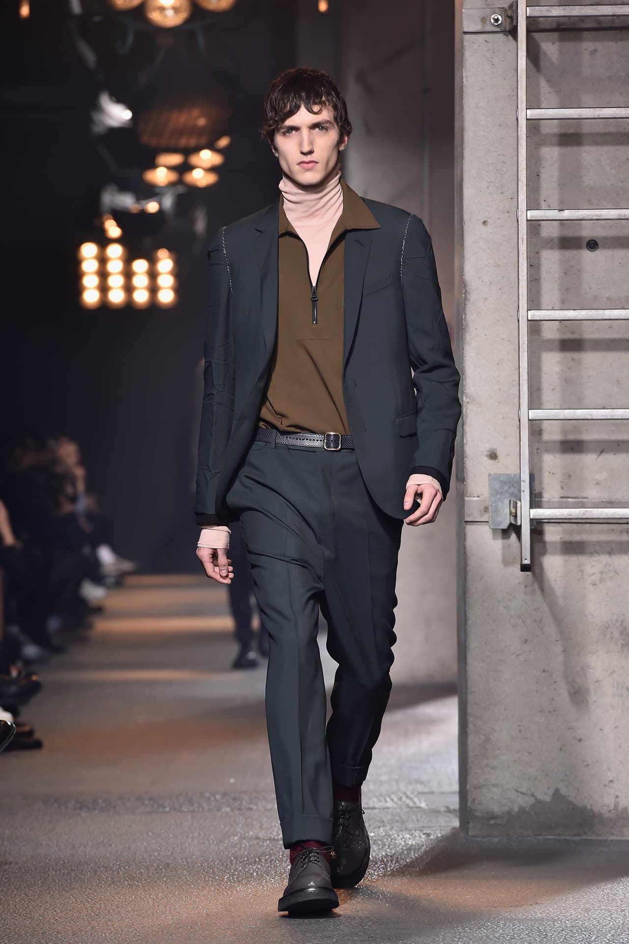 La colección Otoño-Invierno 2016-2017 de Lanvin parece reinventar el cuello de tortuga, una alternativa fresquísima a la ya trillada camiseta. Su combinación con una camisa y traje líquidos, produce una línea viril y sofisticada que estiliza y alarga una constitución como la de J Balvin. 
<br>