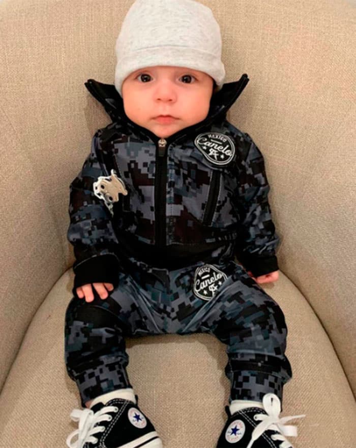 <a href="https://www.univision.com/radio/radio-nacional/en-fotos-la-inusual-historia-de-como-saul-canelo-alvarez-se-convirtio-en-padre-cuatro-veces-fotos">Su hijo menor</a>, Saúl Abdiel, también viste con ropa de marca, como se puede apreciar en esta fotografía de 2019: su outfit ostenta el logo de Tous.