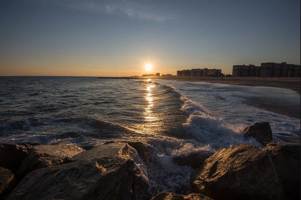 <b>Rockaway Beach </b>en Nueva York en verano es para nadar y tomar el sol. Algunos visitantes practican deportes como el volleyball y andar en patineta. Los vendedores venden pizza, arepas y hielo italiano durante el verano, y los bares tienen patios llenos de vida.