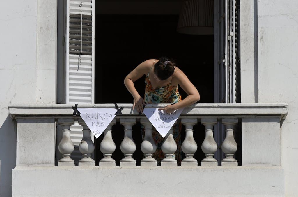 Bajo estricta cuarentena en Argentina, una mujer decora su balcón con pañuelos blancos, el símbolo de las Madres de Plaza de Mayo, en Buenos Aires, en el 44 aniversario del último golpe militar en 1976, el 24 de marzo de 2020.