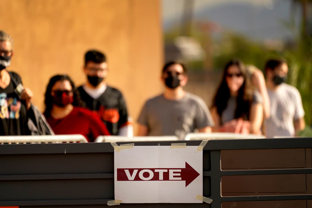 Los votantes hacen fila afuera de una mesa de votación, el martes 3 de noviembre de 2020, en Mesa, Arizona.