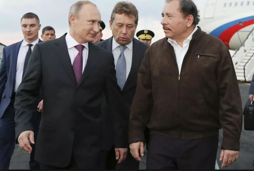 Russia's President Vladimir Putin (2nd L) speaks to Nicaragua's President Daniel Ortega (R) after he arrived at the international airport in Managua July 11, 2014.