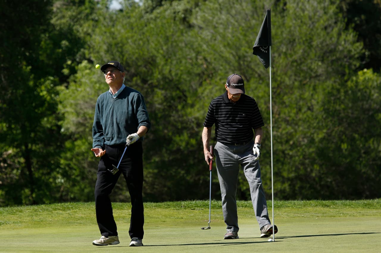 Golfistas el club Haggin Oaks, de Sacramento, California. El director de salud de ese condado designó al golf como una actividad esencial para la comunidad. Los deportistas deben mantener las normas de distanciamiento social, higiene, y sin reunirse en grupos.