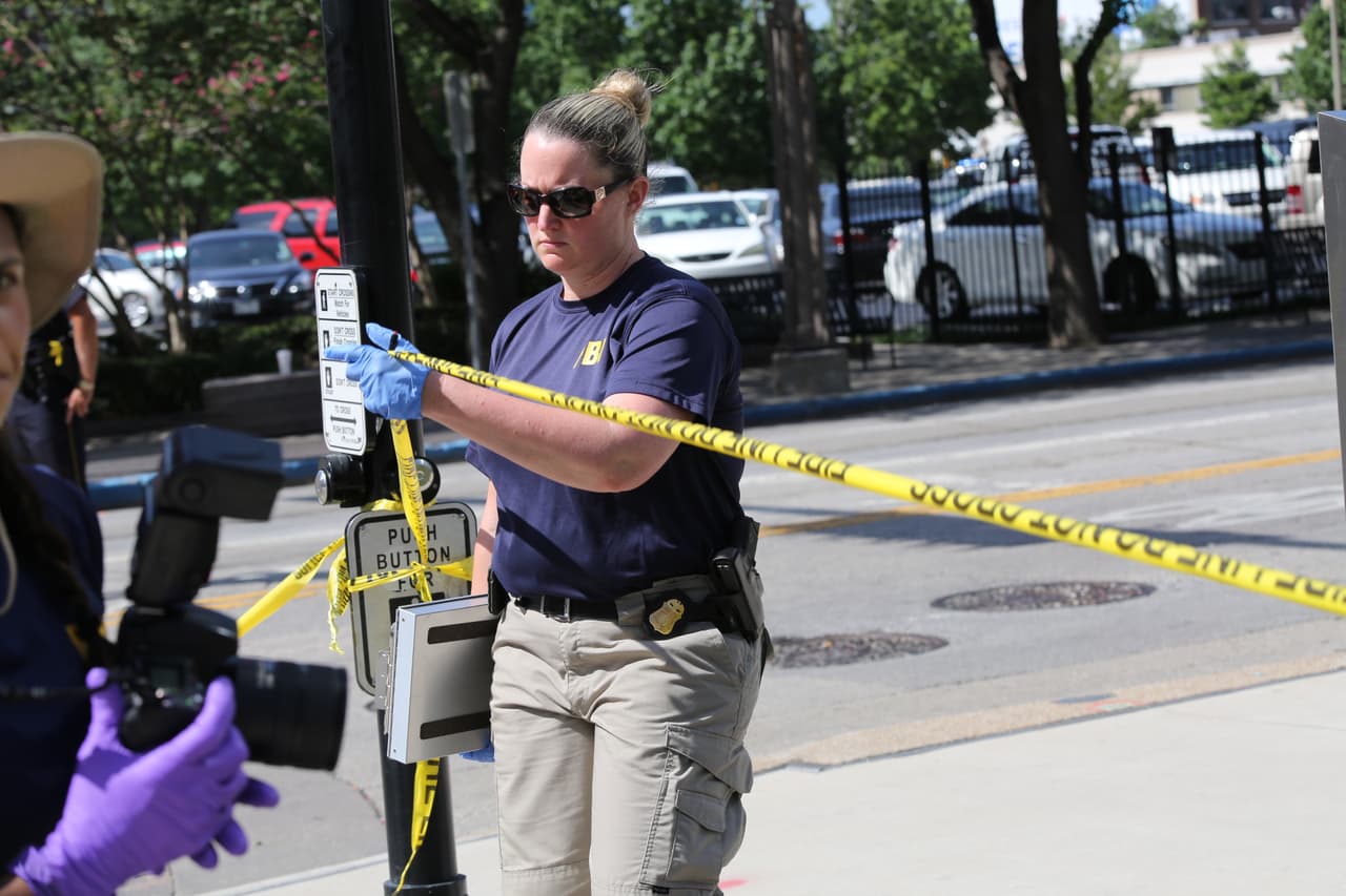 Un agente del FBI colocá una nueva línea policial para recabar evidencia cerca de un estacionamiento donde hay decenas de autos que no fueron permitidos ser recogidos por sus propietarios.