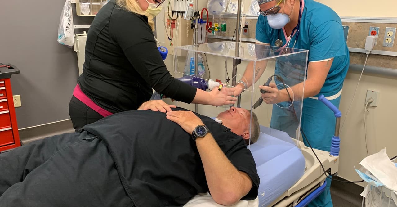 Ejemplifican el uso de la caja que tiene un costo de 160 dólares y es reutilizable. Aseguran que protege a los profesionales de la salud del contagio.