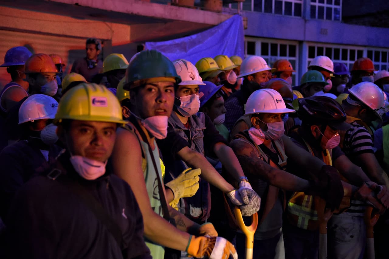 Volunteer rescuers stand by for their turn to arrive to take part in the cleanup of rubble from collapsed buildings in search of survivors, in Mexico City, on September 20, 2017 one day after a powerful 7.1-magnitude quake devastated part of the country. At least 216 people were killed when a powerful 7.1-magnitude earthquake struck Mexico on Tuesday, including 21 children crushed beneath an elementary school that was reduced to rubble. / AFP PHOTO / Alfredo ESTRELLA (Photo credit should read ALFREDO ESTRELLA/AFP/Getty Images)