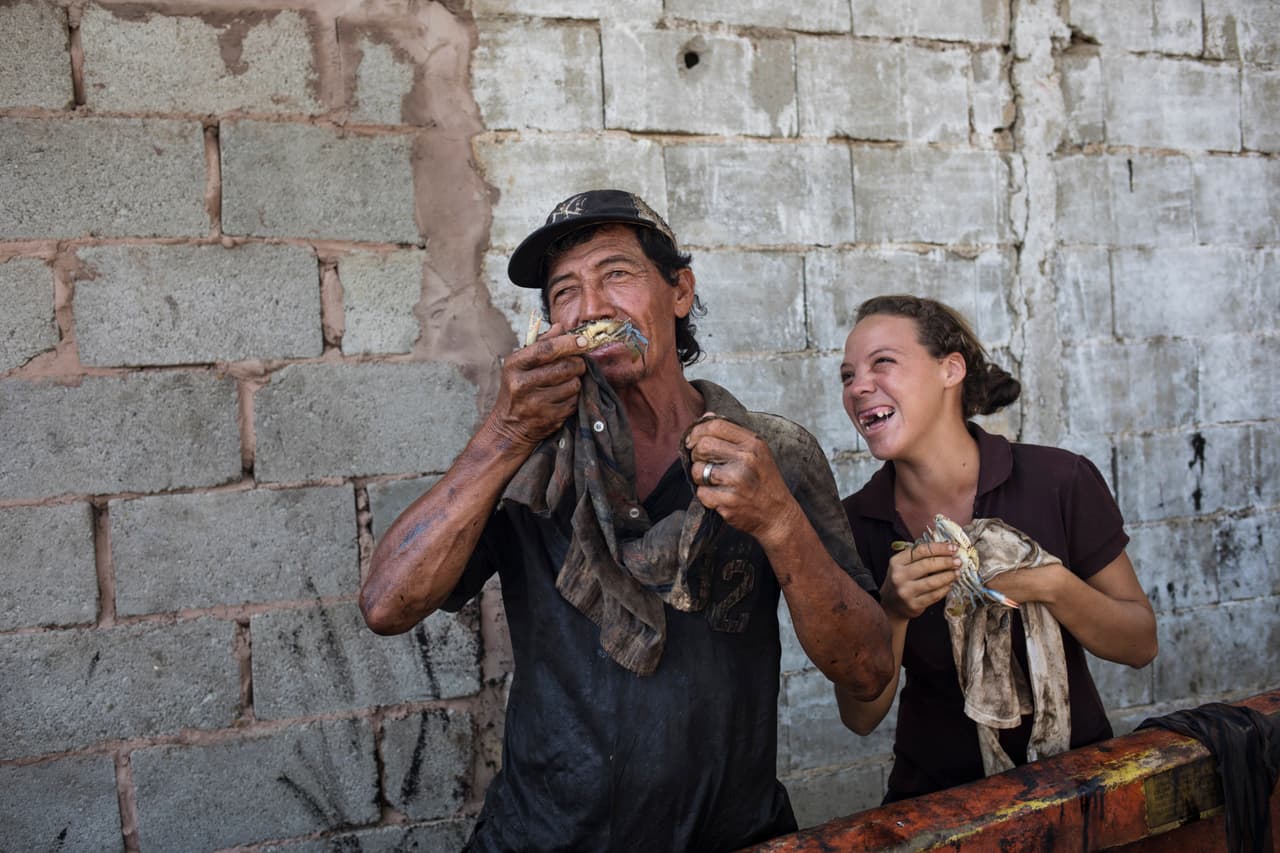 El pescador Antonio Tello bromea con su hija Génesis mientras limpian el petróleo de los cangrejos. La carga se lleva a plantas procesadoras y de allí al mercado nacional o internacional, pero en ninguna parte se informa que fueron sacados de aguas contaminadas. Parte de este producto procesado se lleva a la vecina Colombia y a EEUU.