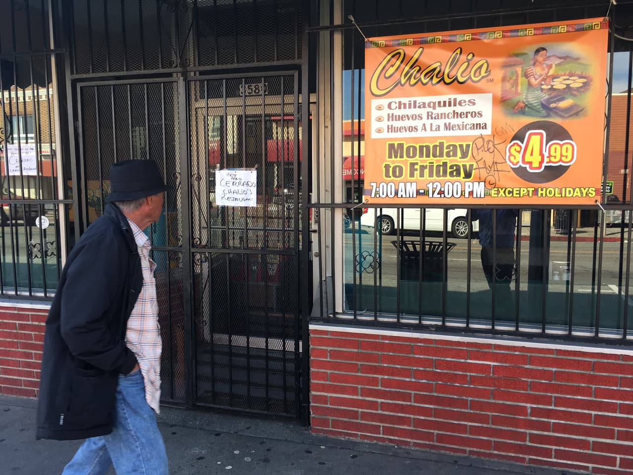 Un peatón pasa delante de un restaurante mexicano en Los Ángeles que cerró sus puertas por el día sin inmigrantes este 16 de febrero. En la puerta se observa un cartel de 'cerrado'.