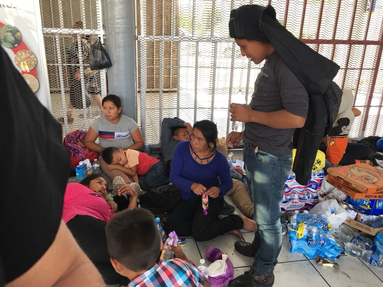 Niños pequeños junto a sus madres a la espera de cruzar a Nogales, Arizona.