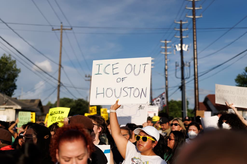 Una mujer sostiene un cartel que dice "ICE FUERA DE HOUSTON" durante una vigilia por Lorenzo Salgado Araujo, un ciudadano mexicano que murió tras recibir un disparo de un agente federal de inmigración el día anterior, el miércoles 8 de julio de 2026, en Houston. (Foto AP/Mark Felix)