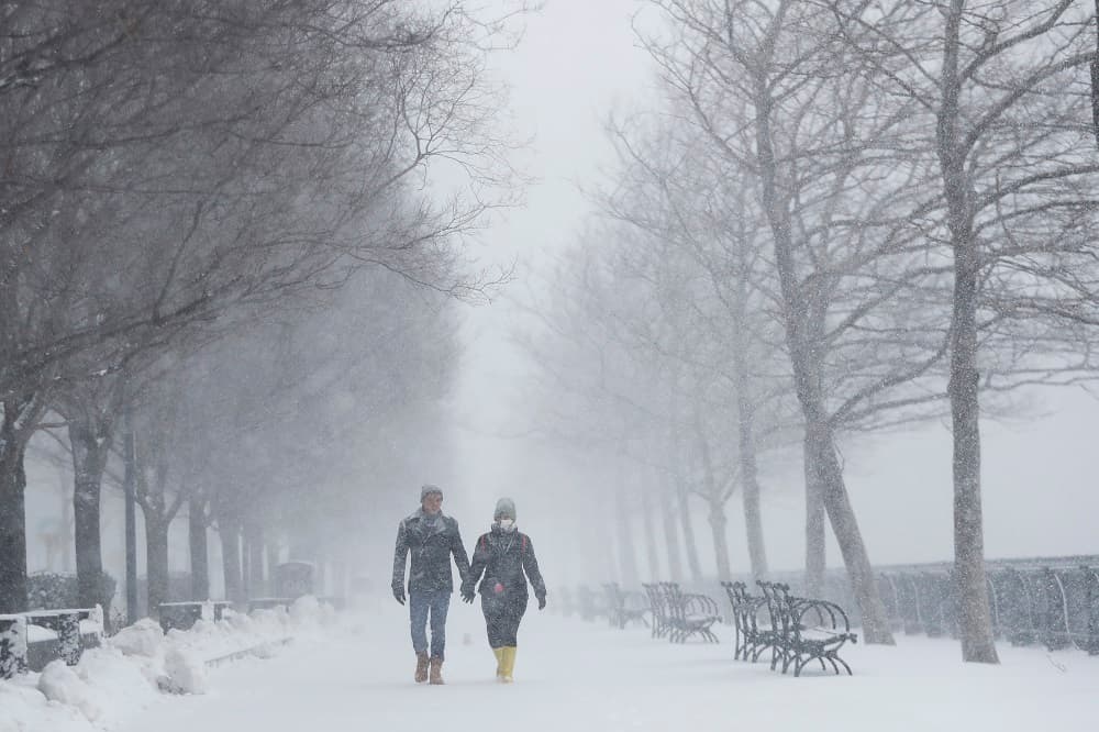 Una pareja camina por un parque en Hoboken, Nueva Jersey, bajo la tormenta que ha hecho que se cancelen al menos 2,800 vuelos.
