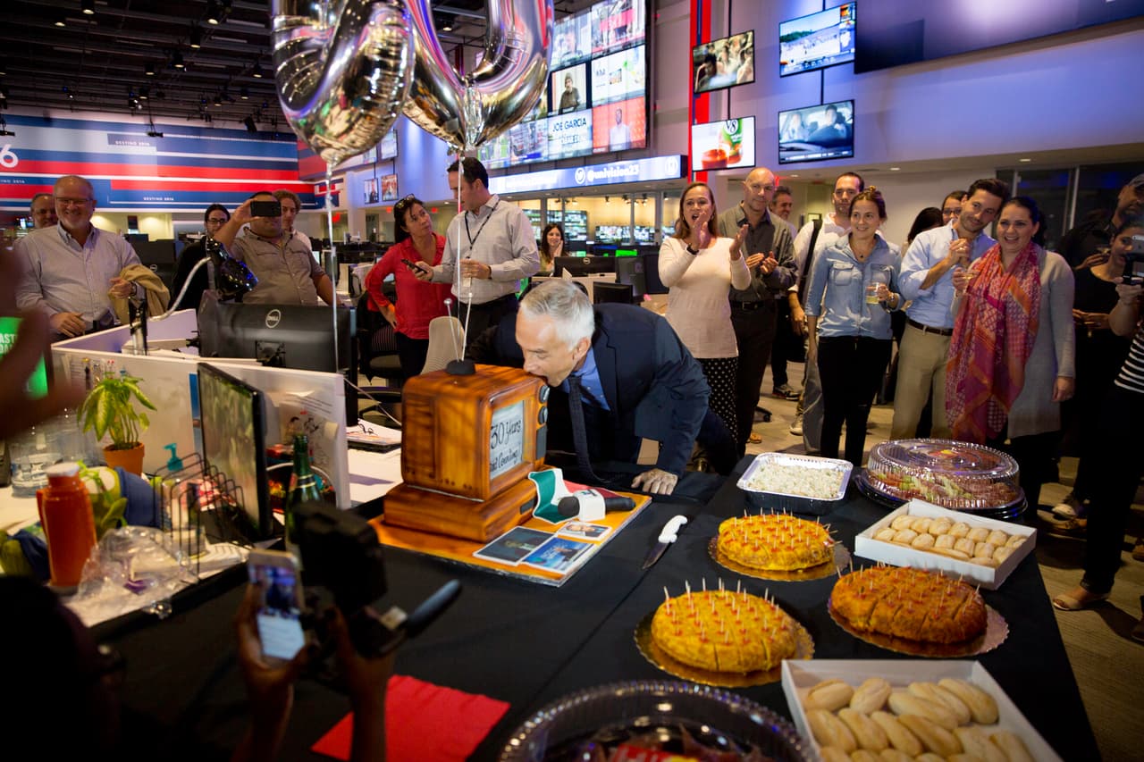 No podía faltar el pastel en la celebración: con forma de televisión y con fotos del recuerdo, una bandera de su país (México)... ¡y la primera mordida para la foto!