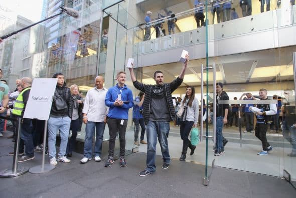 Alice Clarke le presume a la multitud su nuevo iPhone 6 al salir de una tienda Apple de Sydney, Australia.
