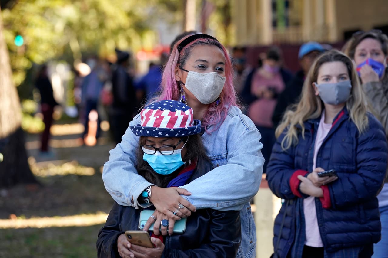 Erin Doherty abraza a su madre Susanna Dew, de 61 años, quien vota por primera vez en su vida. Esperan en la fila en un lugar de votación de Nueva Orleans, Louisiana. Ya han votado anticipadamente, tanto en persona como por correo, 
<a href="https://www.univision.com/noticias/politica/elecciones-en-eeuu-2020/hacia-una-participacion-record-mas-de-100-millones-de-personas-votaron-de-forma-anticipada-en-estas-elecciones-en-eeuu">más de 100 millones de estadounidenses.</a>