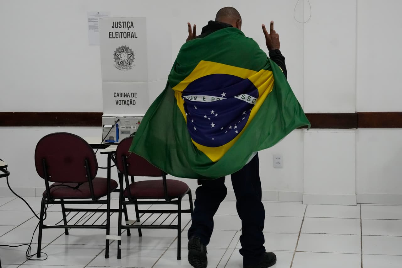 Un hombre envuelto en una bandera brasileña llega a Brasilia, Brasil, para votar en la segunda vuelta de las elecciones presidenciales, el domingo 25 de octubre de 2026.