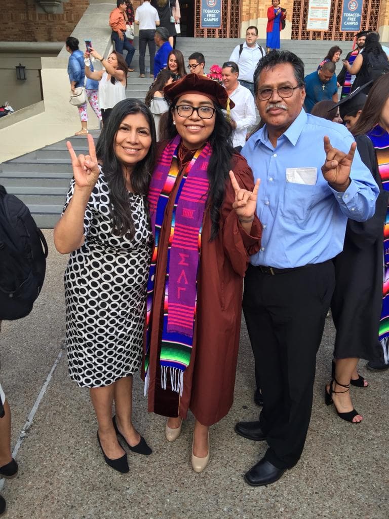 Cisneros posa junto a sus padres el día que se graduó de abogada.