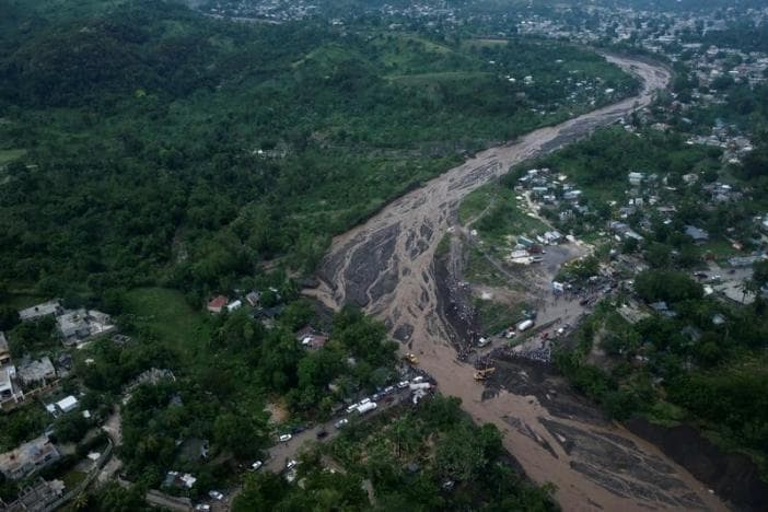 People gather next to a collapsed bridge after Hurricane Matthew passes Petit Goave, Haiti, October 5, 2016.