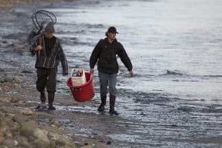 Residentes del área afectada por el derrame caminan por una de las playas afectadas.