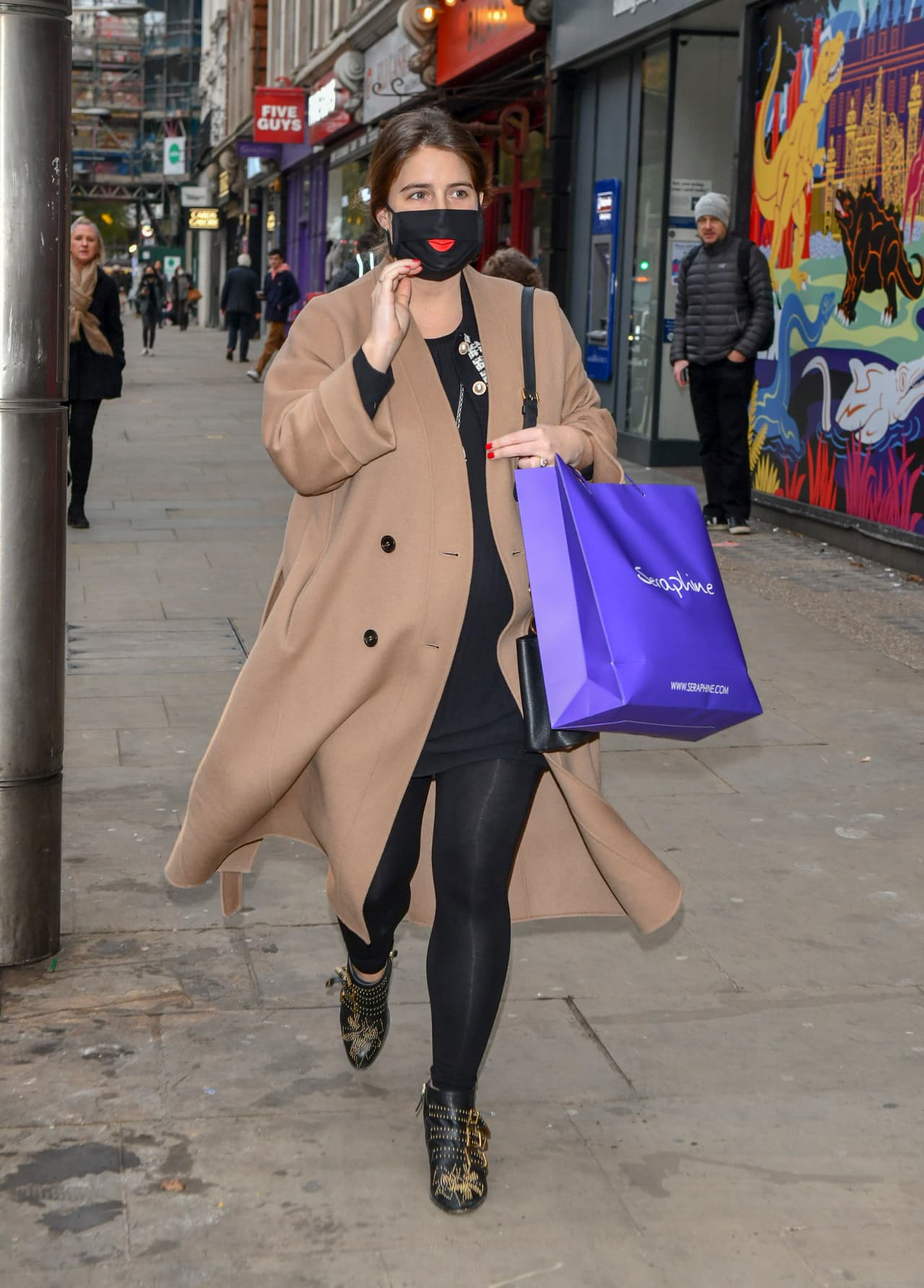 En esa ocasión prefirió portar un vestido negro y un abrigo largo color caqui. Llevaba el mismo cubreboca negro con estampado de labios rojos.