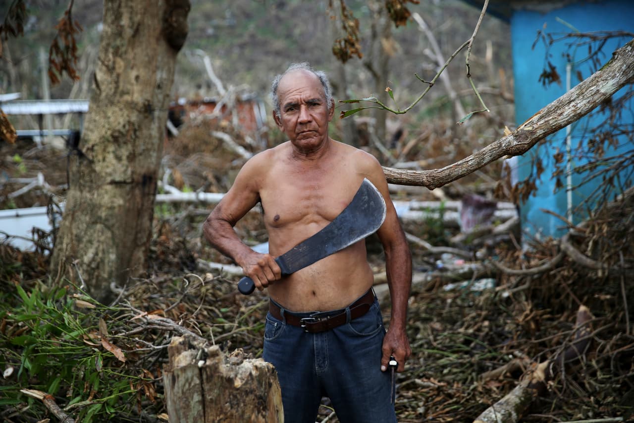 El veterano del Ejército estadounidense, Luis Cabrera Sánchez, sostiene su machete mientras hace una pausa para un retrato mientras limpia los restos de su casa dañada.
