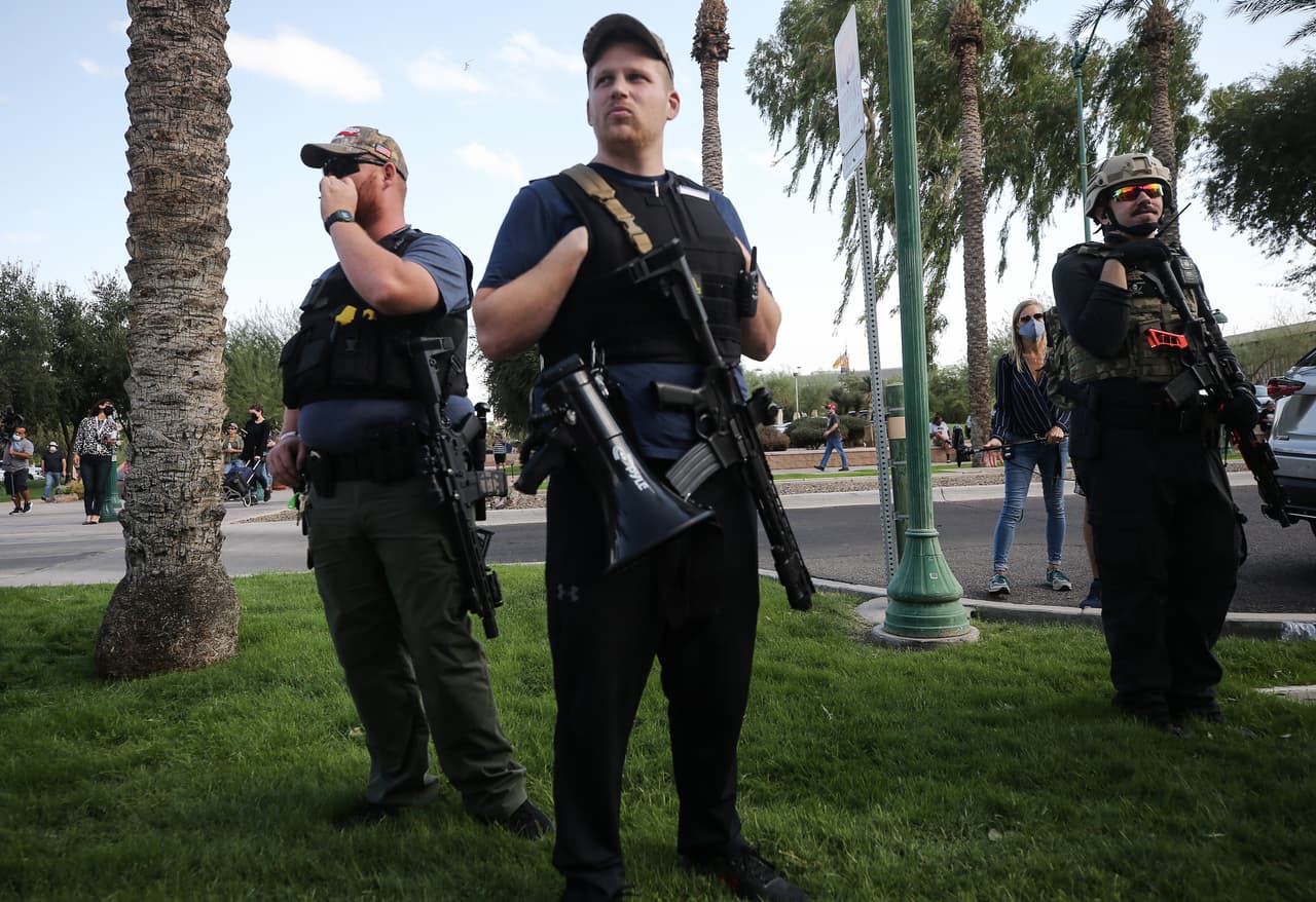 Los partidarios del presidente Donald Trump se paran con rifles en un mitin de "Stop the Steal" frente al Capitolio del Estado el 7 de noviembre de 2020 en Phoenix, Arizona.