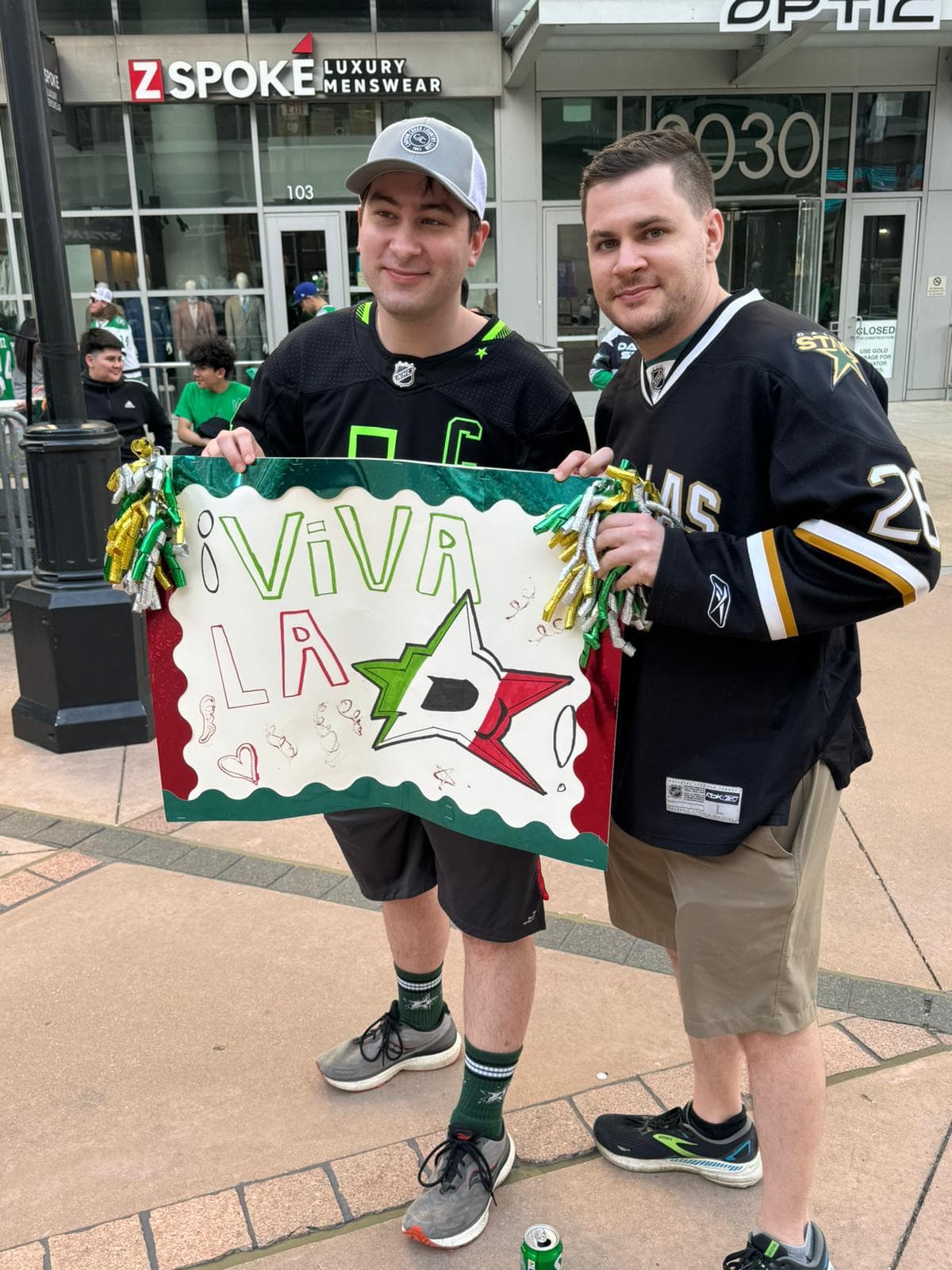 Con pancartas aficionados latinos celebran afuera del American Airlines Center de Dallas.