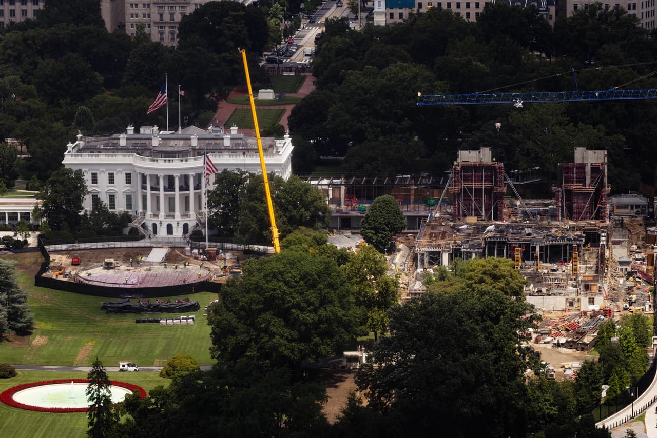 Una vista aérea muestra el contraste entre la Casa Blanca y la enorme zona de construcción que se extiende a un costado del edificio. Grúas, estructuras de acero y trabajadores ocupan el terreno donde avanza el proyecto del nuevo salón de baile.