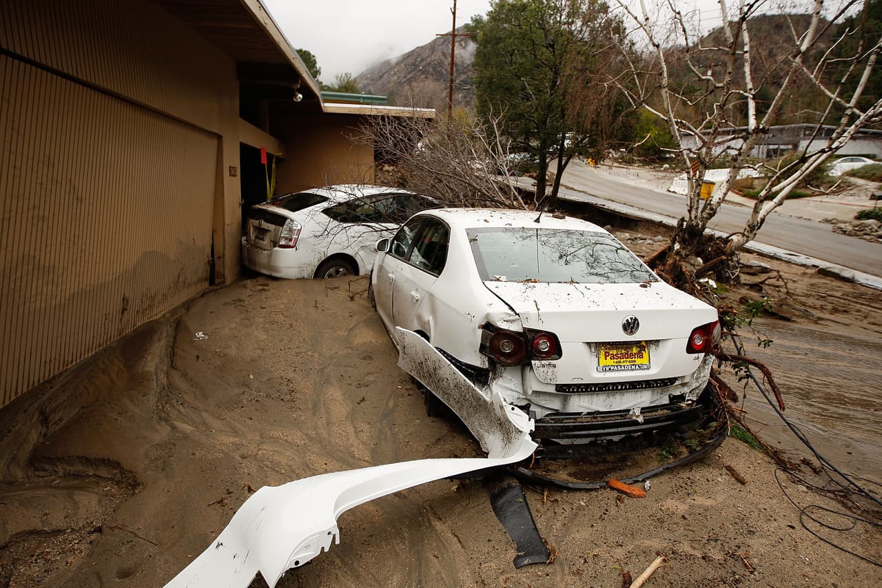 LA CANADA-FLINTRIDGE, CA - FEBRUARY 6: A debris flow damages homes and carries cars away on after heavy rains caused mudslides February 6, 2010 in La Canada Flintridge, California. Large wildfires in 2008 and 2009 stripped the hills and mountains of vegetation, resulting in mud and debris flow danger as winter rains pass over foothill communities where thousands of people have been evacuated at times in recent weeks. The threat is particularly high near the San Gabriel Mountains above La Canada-Flintridge area which were denuded of natural flood-controlling vegetation by the 250-plus square mile Station. At least 40 homes have been severely damaged and 500 remain evacuated. (Photo by David McNew/Getty Images)