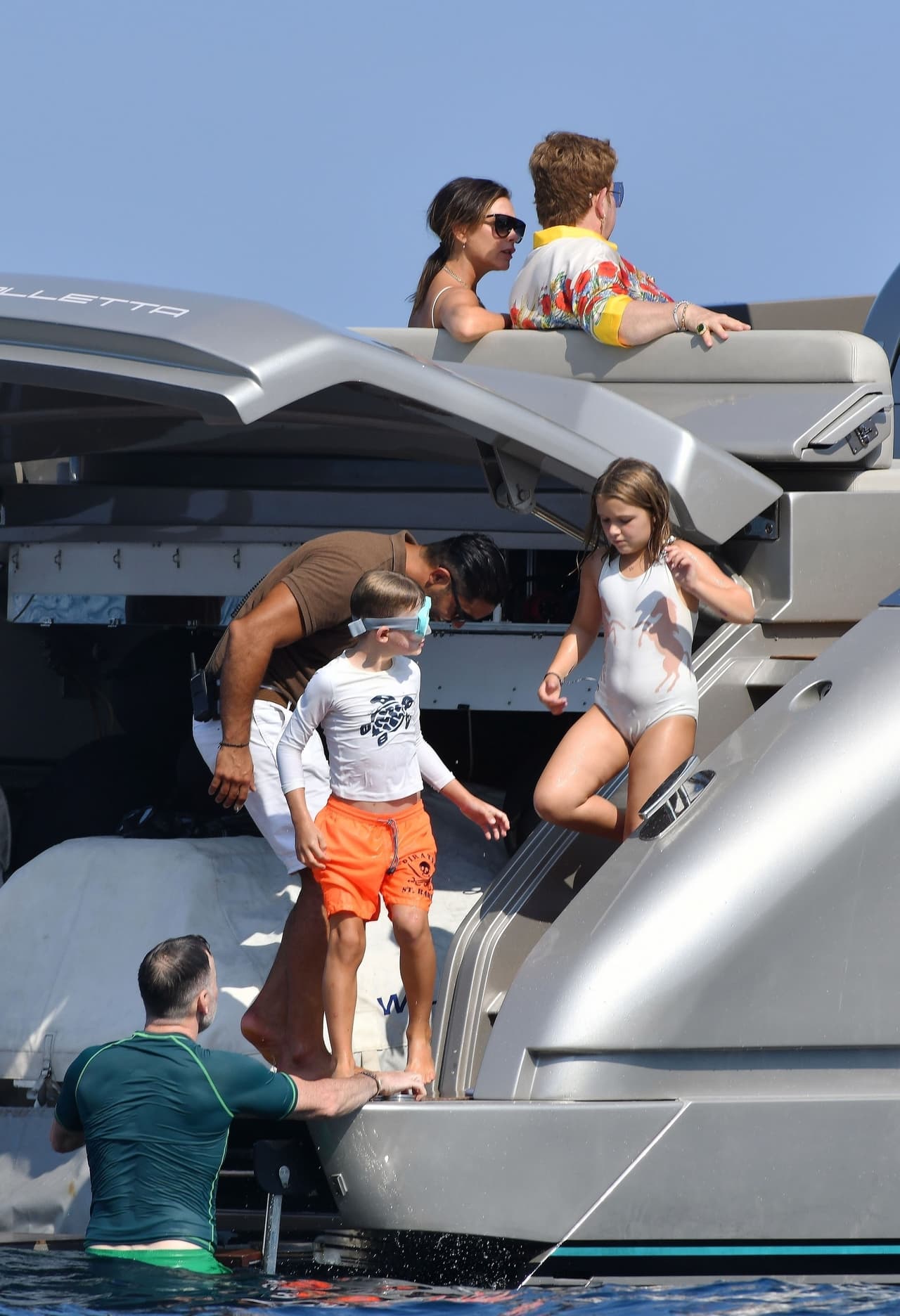 Junto a 
<b><a href="https://www.univision.com/famosos/david-y-victoria-beckham-celebran-20-anos-de-casados-con-un-divertido-regalo-de-su-hija-harper-fotos">Harper Beckham</a></b>, de 8 años, el pequeño Elijah fue a pedirle ayuda a su papá, David Furnish (de verde), para lograr lanzarse al agua desde el punto donde lo estaban haciendo los más grandes.