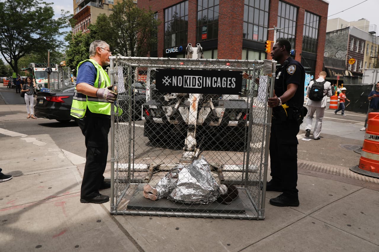 <b>“No a los niños en jaulas"</b>. La policía de Nueva York se lleva una instalación artística que representa a un niño arropado con una cobija térmica dentro de una jaula de alambre. La obra es una crítica a la detención de niños migrantes en EEUU. 
<a href="https://www.univision.com/noticias/inmigracion/la-detencion-de-mas-de-100-000-ninos-migrantes-hace-que-eeuu-sea-el-pais-del-mundo-con-mas-menores-arrestados">Según un informe de Naciones Unidas</a>, EEUU es el país del mundo con 
<a href="https://www.univision.com/noticias/inmigracion/les-estan-causando-danos-masivos-el-trauma-de-los-ninos-migrantes-detenidos-sin-sus-familias-y-como-prisioneros">más menores privados de su libertad</a>, más de 100,000. 12 de junio de 2019.