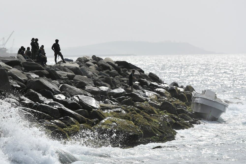 Security forces guard the shore area and a boat in which authorities claim a group of armed men landed in the port city of La Guaira, Venezuela, Sunday, May 3, 2020.