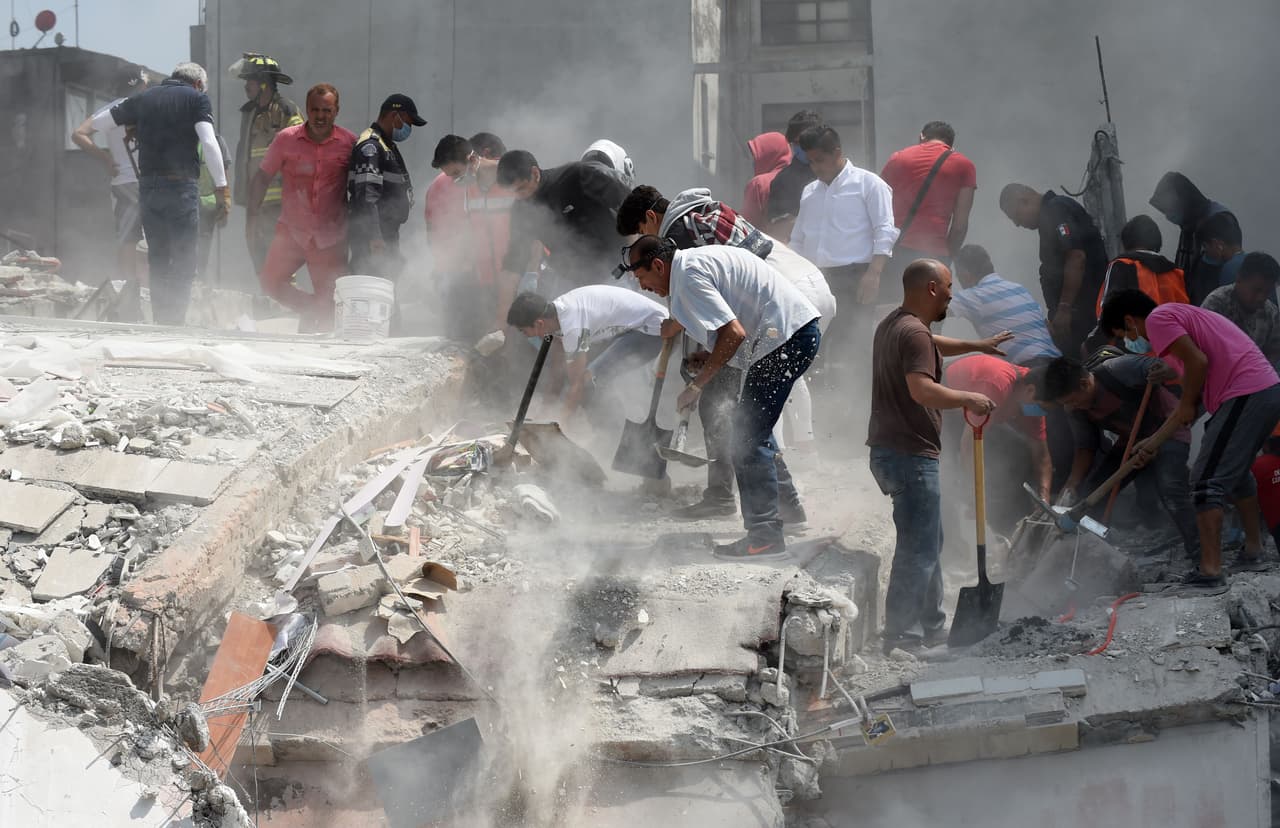 Voluntarios ayudan a remover escombros de un edificio que colapsó en Ciudad de México.