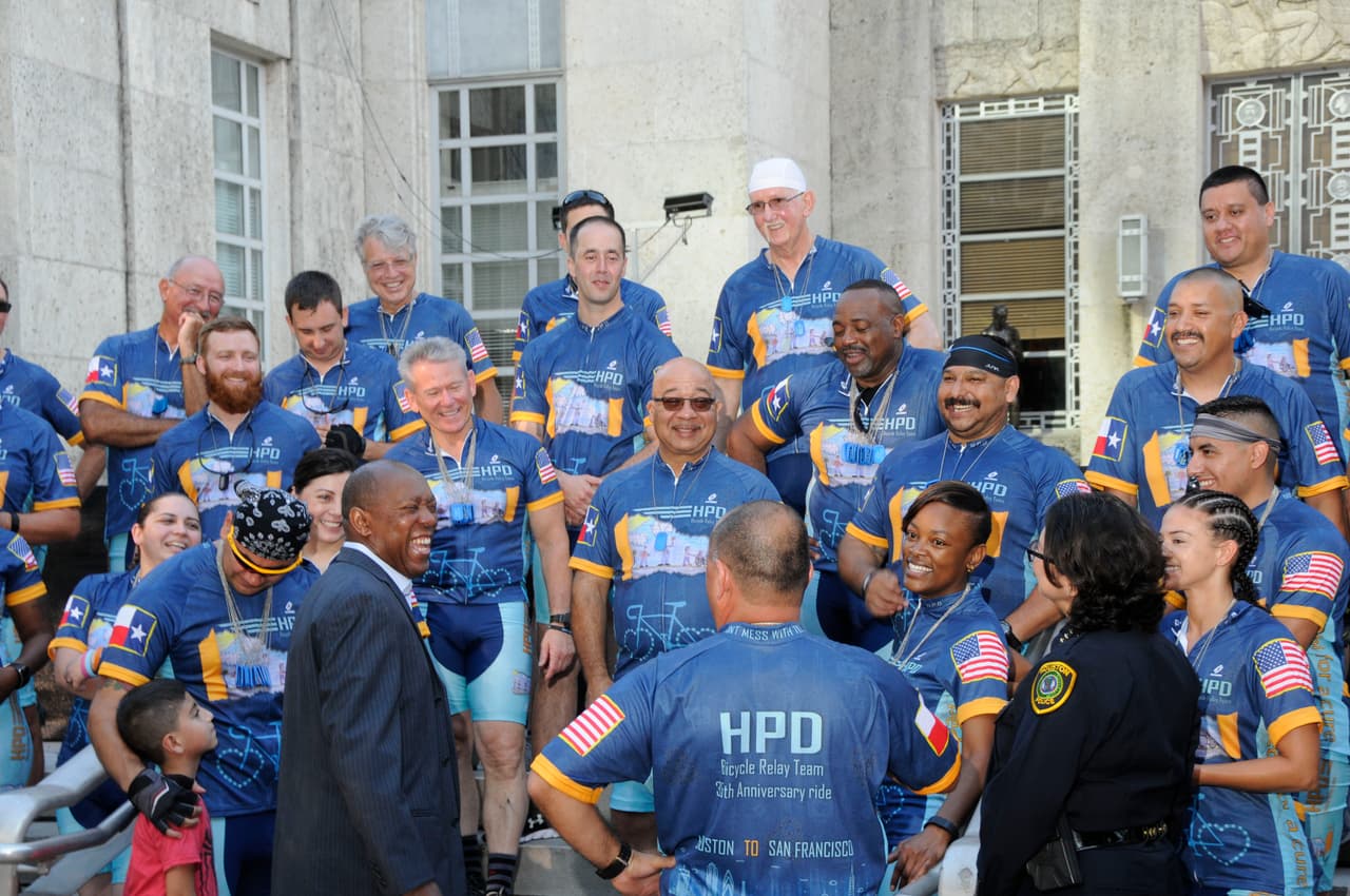 El equipo de ciclistas policías bromea con el alcalde Sylvester Turner antes de emprender el recorrido.