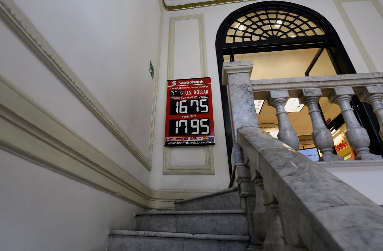 Un cartel de un banco mexicano muestra su tasa de canje del
<b><a href="http://www.univision.com/noticias/divisas/el-peso-mexicano-empieza-2016-perdiendo-cada-vez-mas-terreno-frente-al-dolar">7 de enero de 2016</a></b>. El comienzo del año no fue nada prometedor para el peso, afectado especialmente por la caída del precio del petróleo, la matería prima de la que depende un tercio del presupuesto nacional. (Alfredo Estrella / AFP)