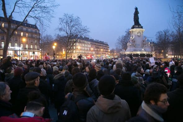 Una multitud se reune silenciosa al pie de la estatua de Marianne, que representa la libertad.